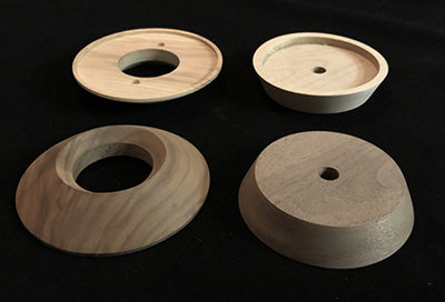 Four turned lamp bases in white birch and walnut, routed, drilled, and sanded for smooth finish.