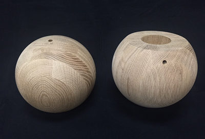 Two 7.5 inch white oak wood balls, drilled and sanded, ready for finishing.
