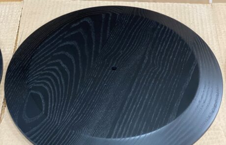 A medallion that was CNC-machined from laminated ash with a hand-rubbed finish.