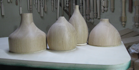 Pendant shades that are laminated and turned in white oak wood.