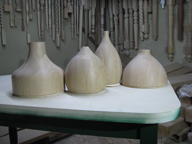 Pendant shades that are laminated and turned in white oak wood.