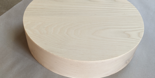 Laminated ash lamp base with clean cylindrical form, CNC routed and drilled for hardware installation.