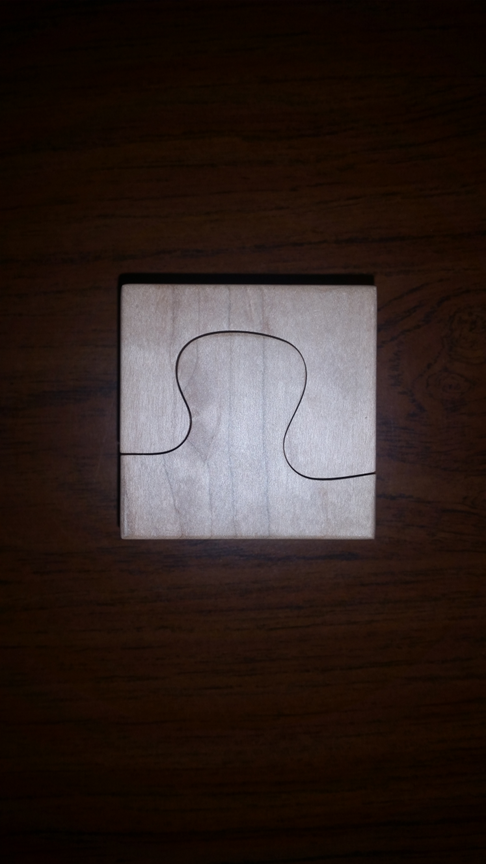 Puzzle-shaped lamp base CNC machined from soft maple wood with curved interlocking profile.