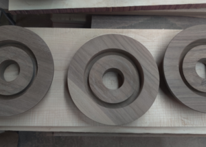 Solid walnut recessed lighting canopies with center bores and CNC-routed stepped profiles.