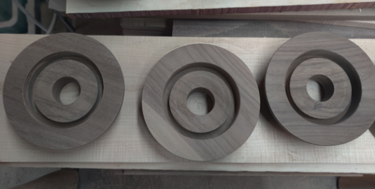 Solid walnut recessed lighting canopies with center bores and CNC-routed stepped profiles.