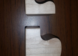 Two interlocking puzzle-shaped lamp base halves CNC machined from soft maple wood.