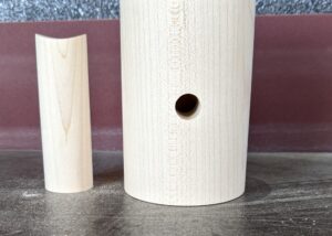 Turned hard maple lighting components with cylindrical and concave forms, drilled for wiring.