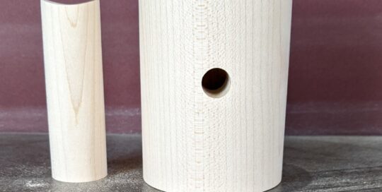 Turned hard maple lighting components with cylindrical and concave forms, drilled for wiring.