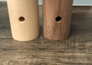 Turned wood lighting components in walnut and hard maple with center bore and side hole.